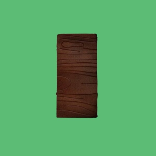 A rectangular chocolate bar with a textured, woodgrain-like pattern on its surface, displayed against a solid green background.